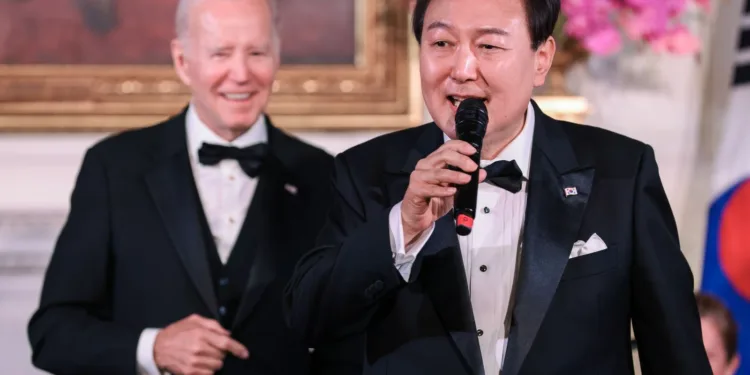 epa10593745 South Korean President Yoon Suk-yeol (R) of the Republic of Korea sings as US President Joe Biden looks on during the State Dinner held in the East Room of The White House in Washington, DC, USA, 26 April 2023.  EPA/Oliver Contreras / POOL